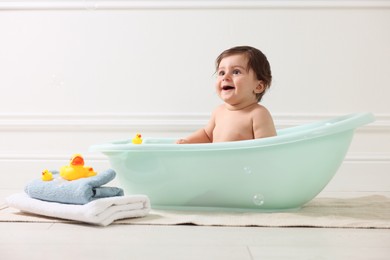Photo of Cute little baby bathing in tub at home