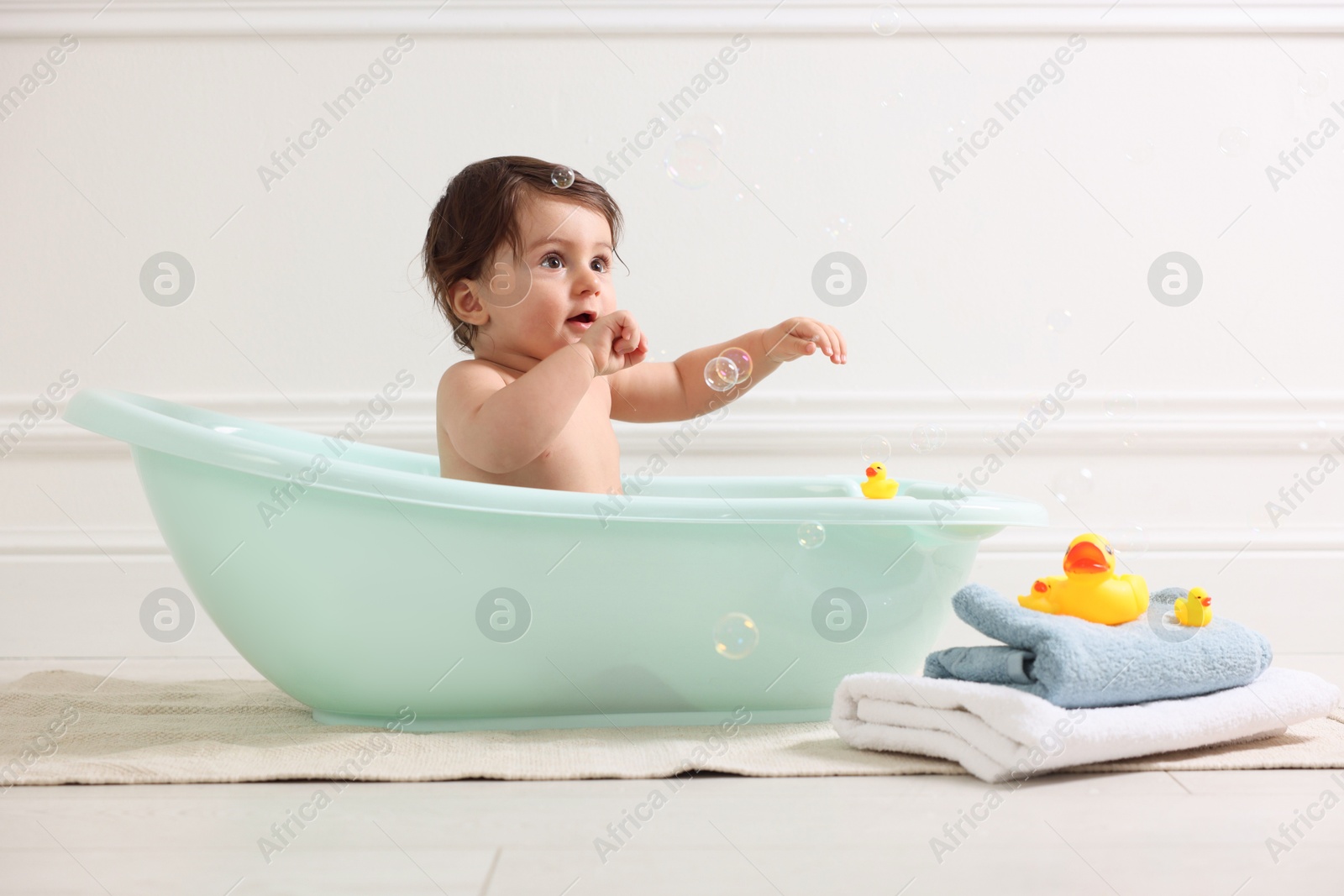 Photo of Cute little baby bathing in tub at home