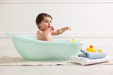 Photo of Cute little baby bathing in tub at home