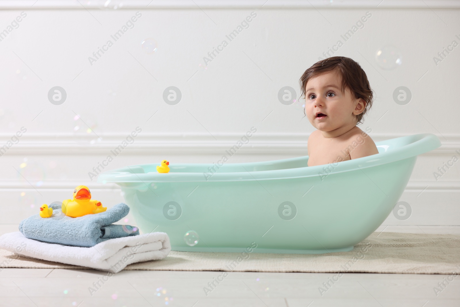 Cute little baby bathing in tub at home Photo of Cute little baby bathing in tub at home