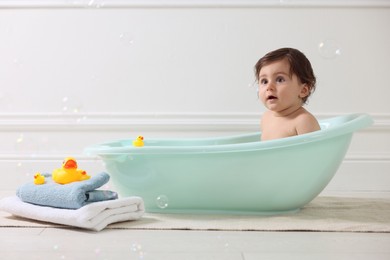 Photo of Cute little baby bathing in tub at home