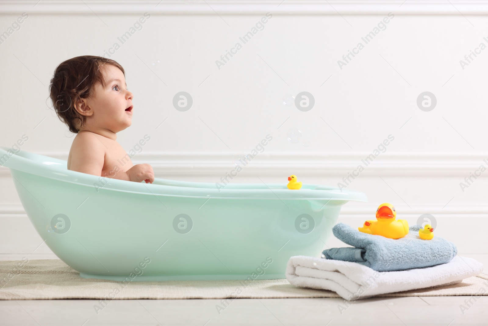 Cute little baby bathing in tub at home Photo of Cute little baby bathing in tub at home