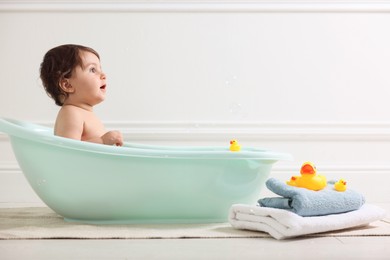 Photo of Cute little baby bathing in tub at home