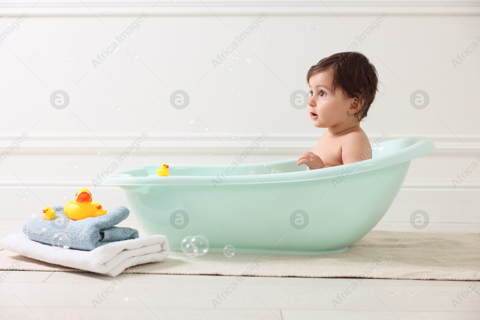 Cute little baby bathing in tub at home Photo of Cute little baby bathing in tub at home