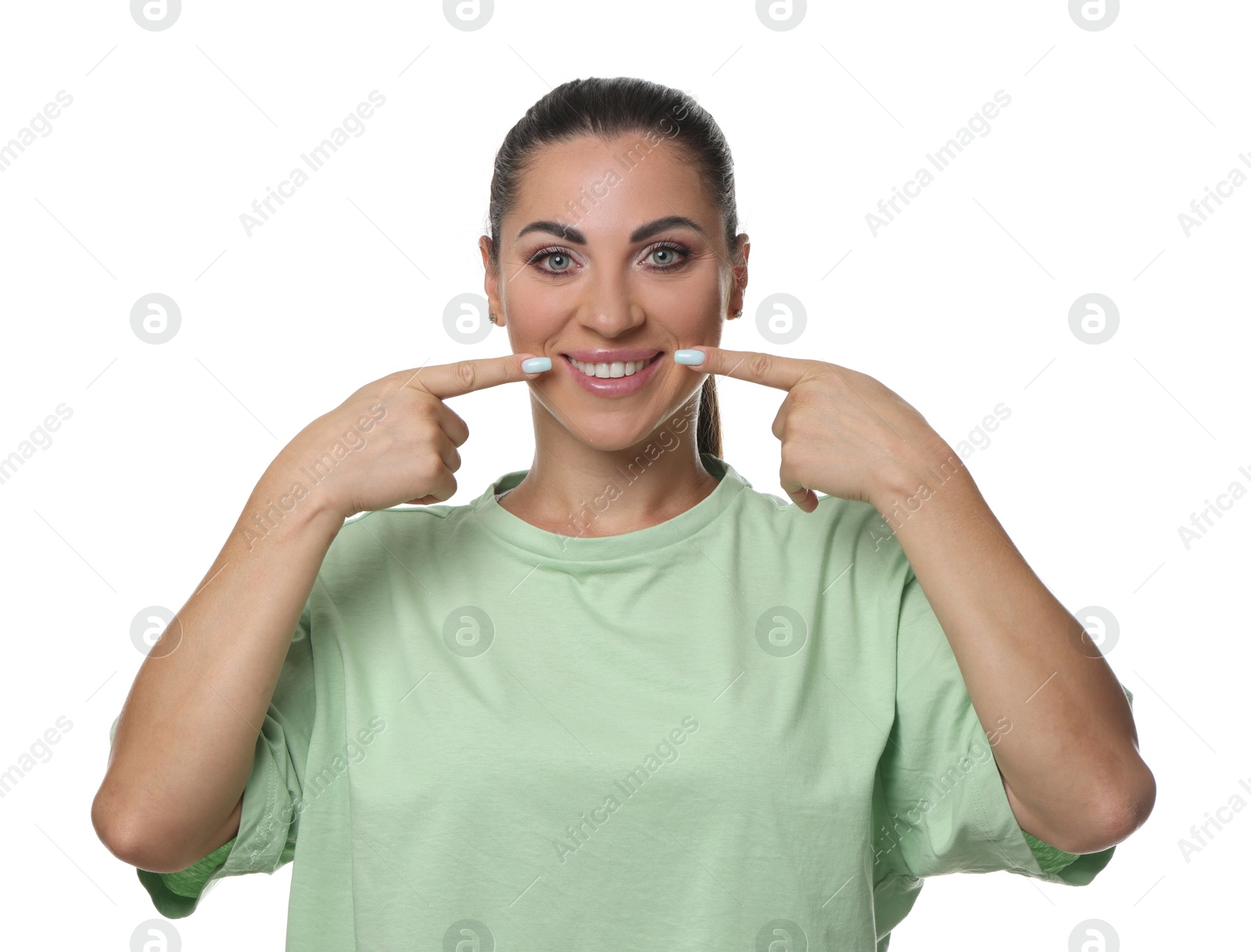 Woman pointing at her healthy teeth on white background Photo of Woman pointing at her healthy teeth on white background