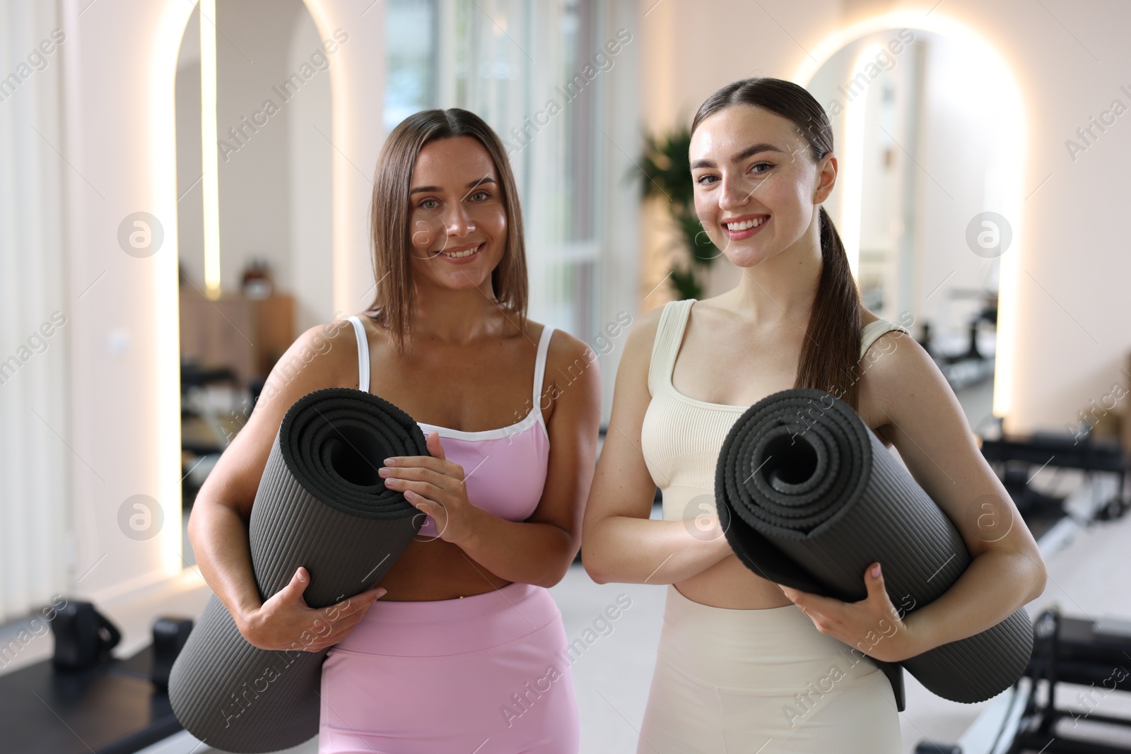 Photo of Women with fitness mats in pilates studio