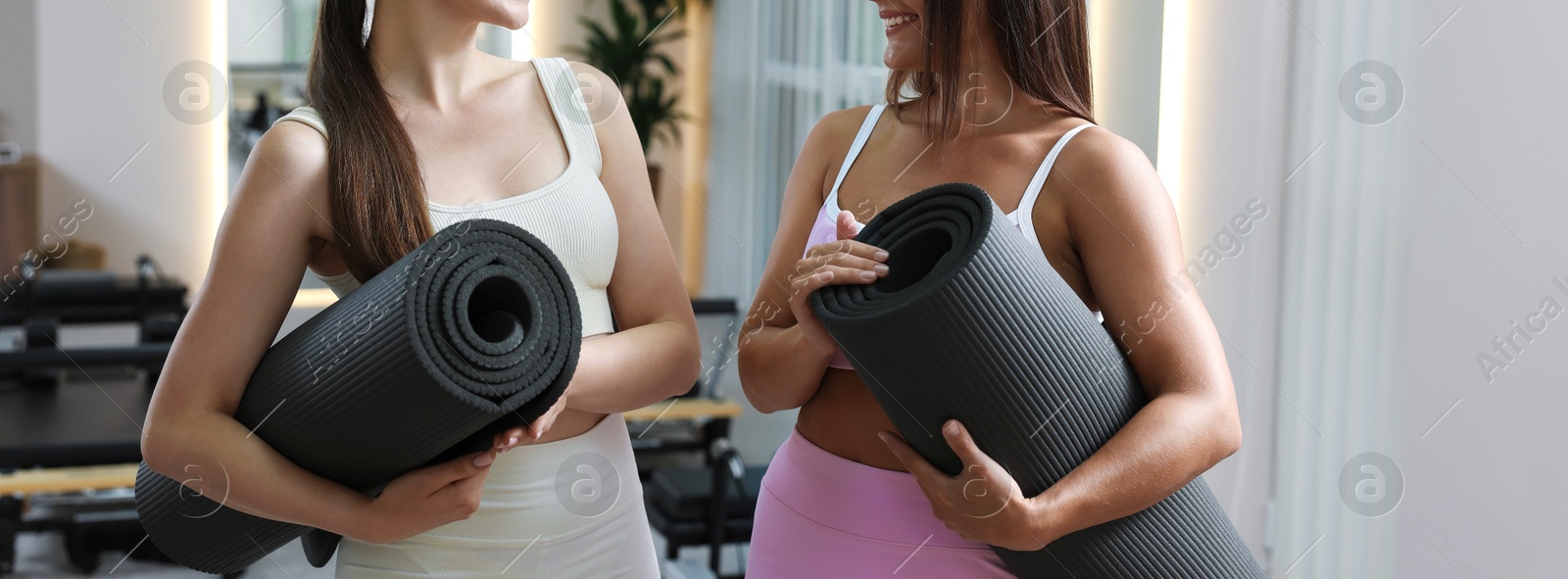 Photo of Women with fitness mats in pilates studio, closeup
