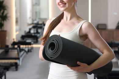 Photo of Woman with fitness mat in pilates studio, closeup