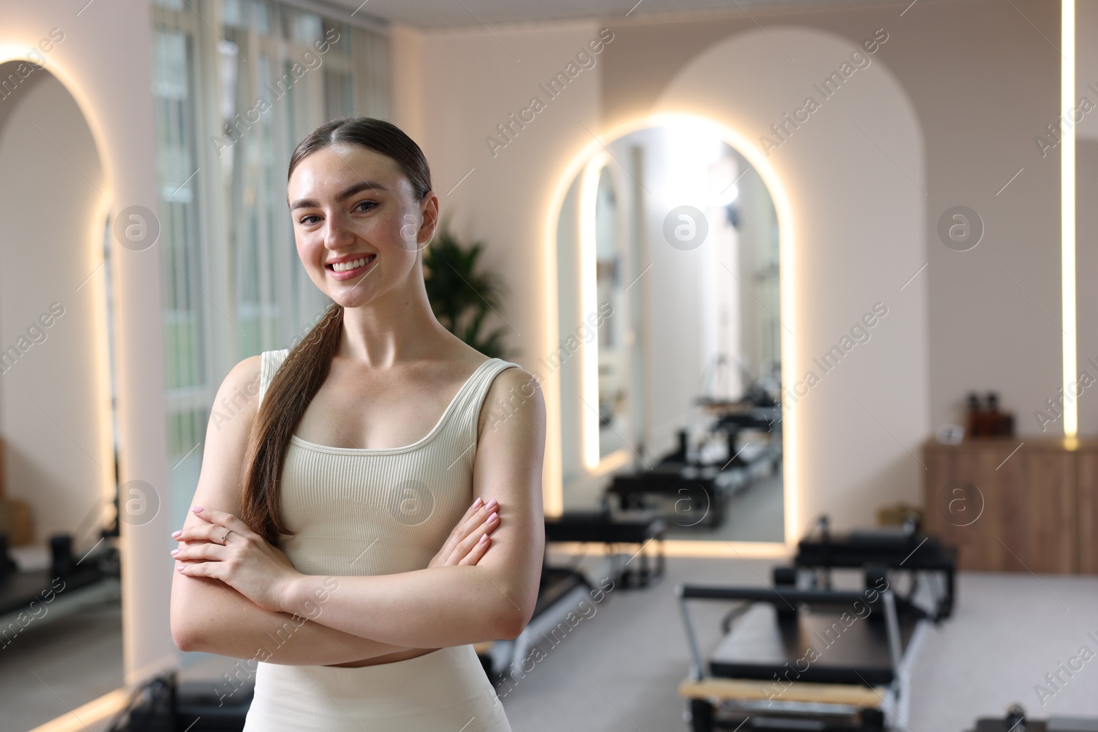 Happy woman wearing sportswear in pilates studio, space for text Photo of Happy woman wearing sportswear in pilates studio, space for text