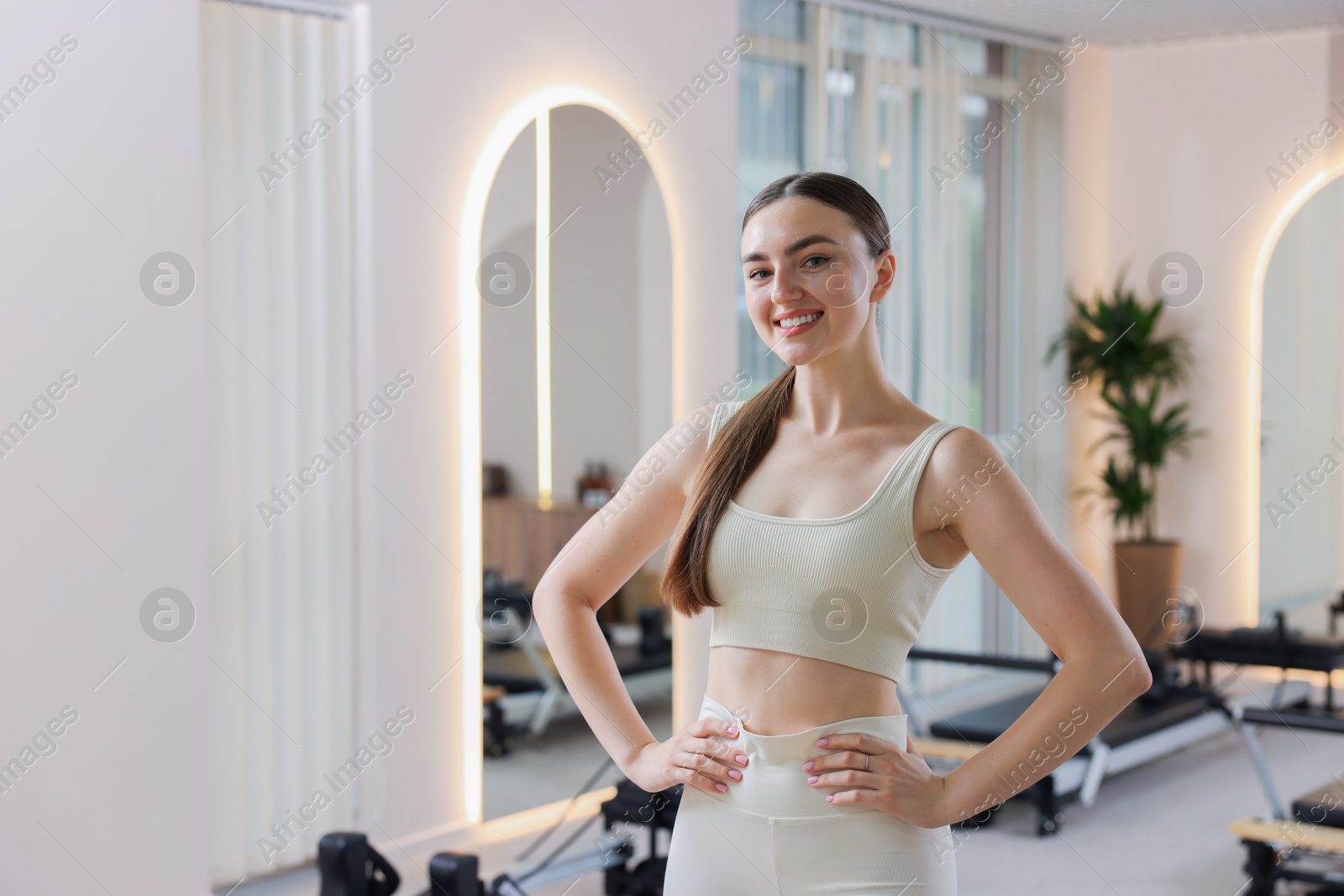 Happy woman wearing sportswear in pilates studio, space for text Photo of Happy woman wearing sportswear in pilates studio, space for text