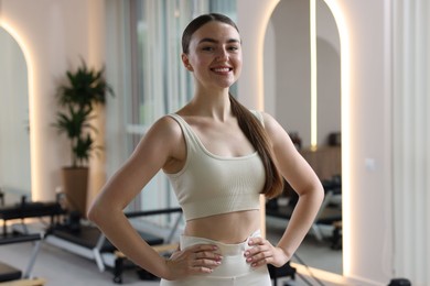 Photo of Happy woman wearing sportswear in pilates studio