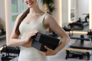 Photo of Woman with foam blocks in pilates studio, closeup