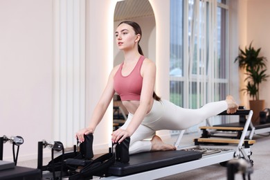 Photo of Woman exercising on reformer in pilates studio