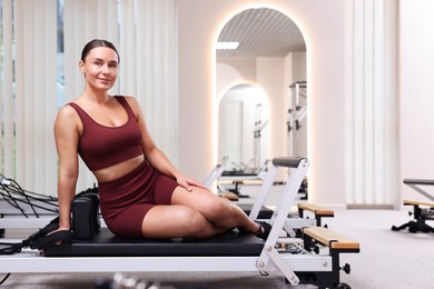 Photo of Happy woman on reformer in pilates studio