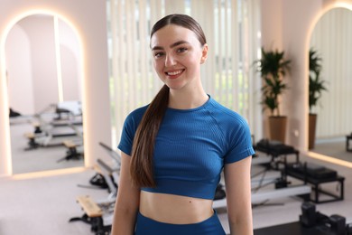 Photo of Happy woman wearing sportswear in pilates studio