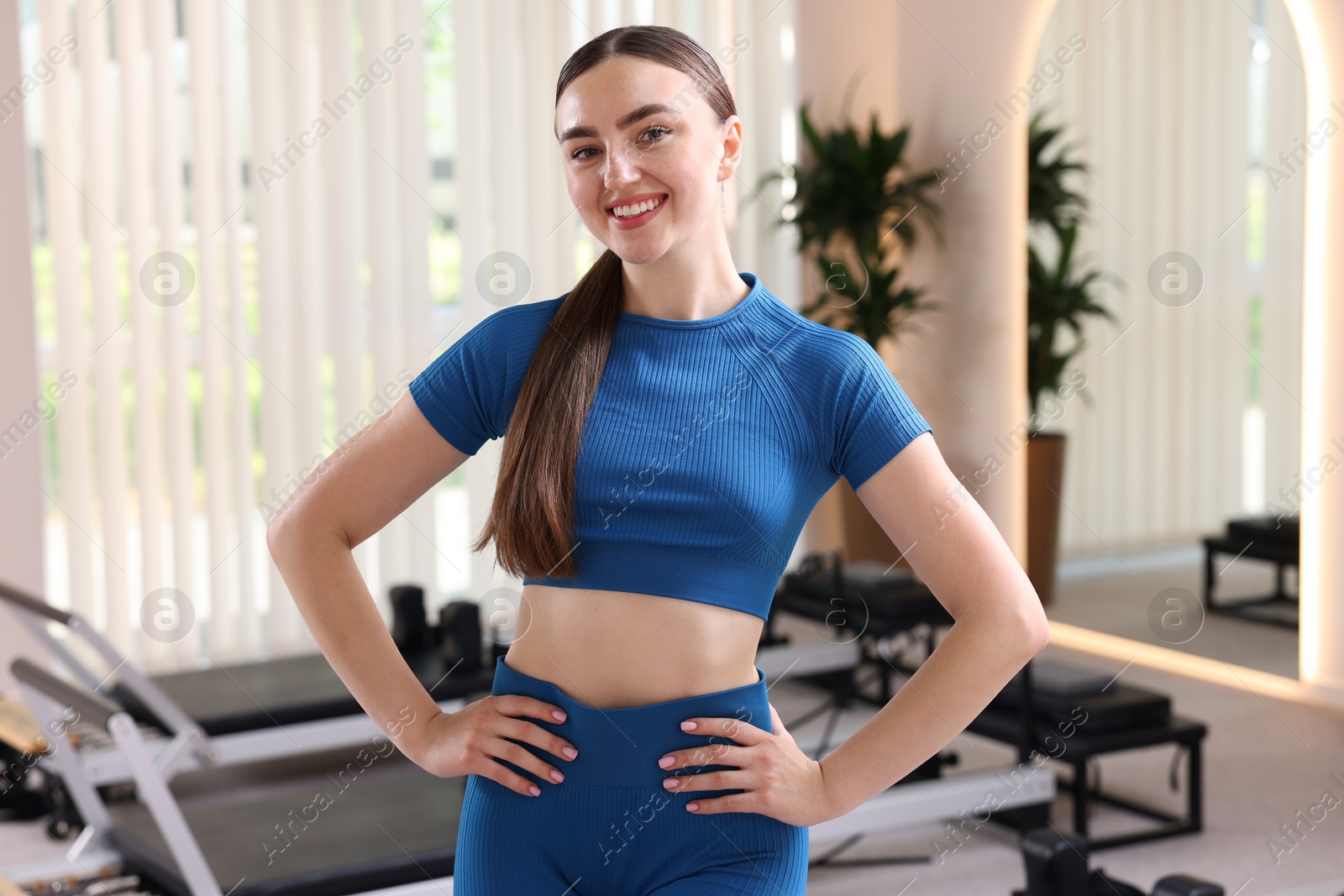 Photo of Happy woman wearing sportswear in pilates studio