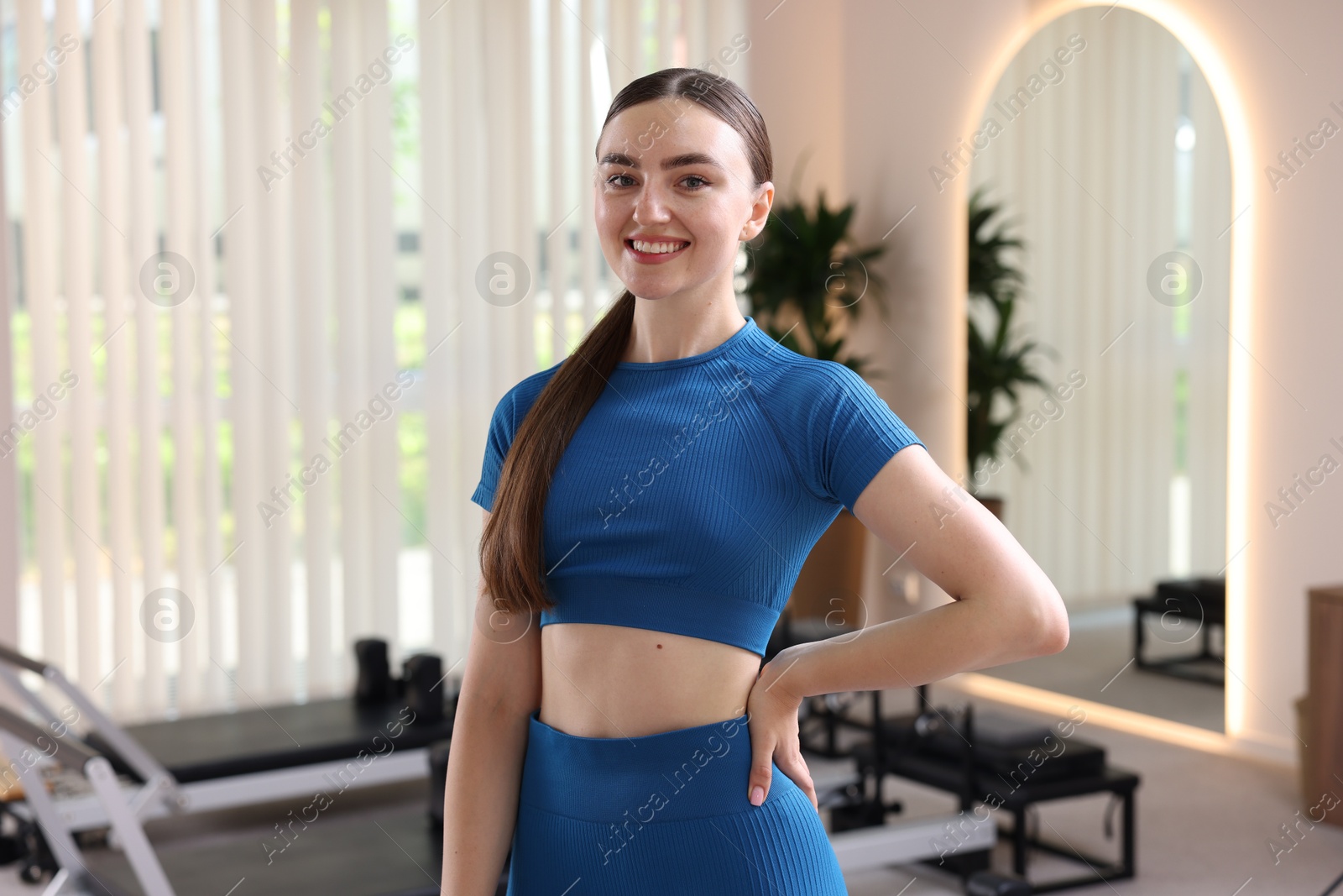 Photo of Happy woman wearing sportswear in pilates studio