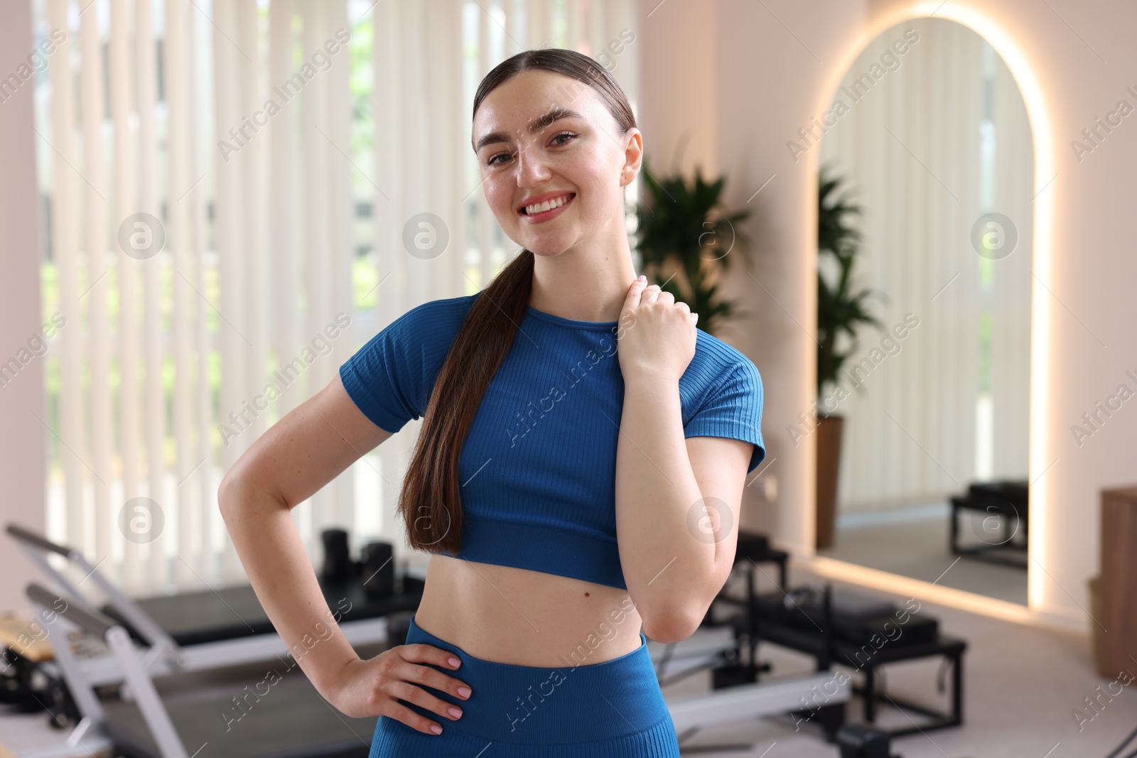 Photo of Happy woman wearing sportswear in pilates studio