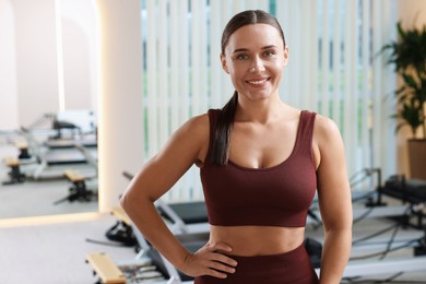 Photo of Happy woman wearing sportswear in pilates studio
