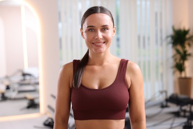Photo of Happy woman wearing sportswear in pilates studio