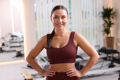 Photo of Happy woman wearing sportswear in pilates studio