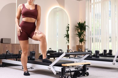 Photo of Woman near reformer in pilates studio, closeup