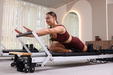 Photo of Woman exercising on reformer in pilates studio