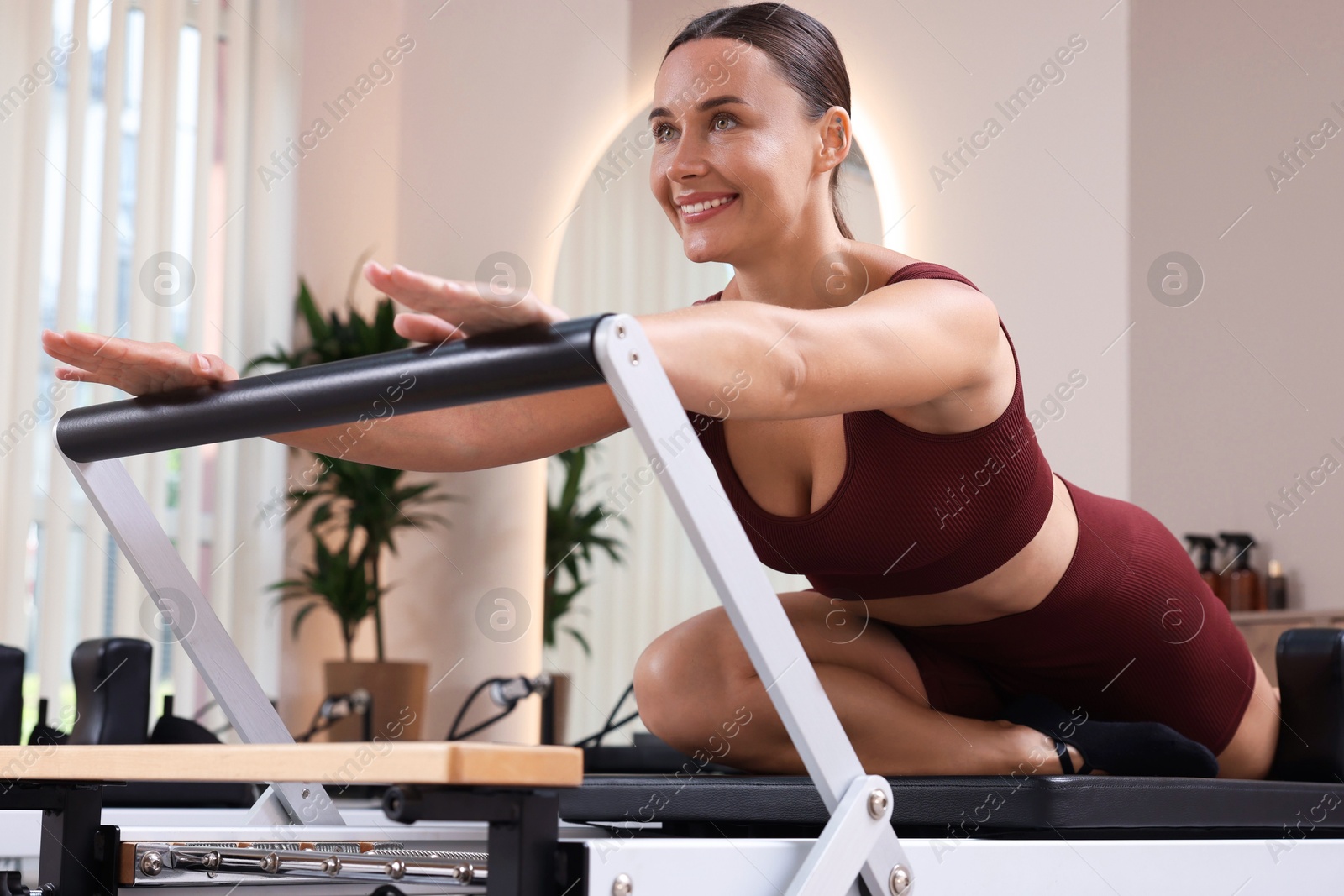 Photo of Woman exercising on reformer in pilates studio