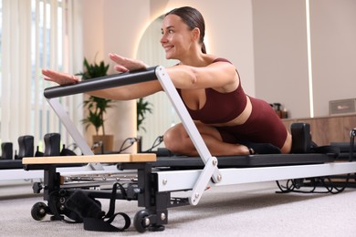 Photo of Woman exercising on reformer in pilates studio