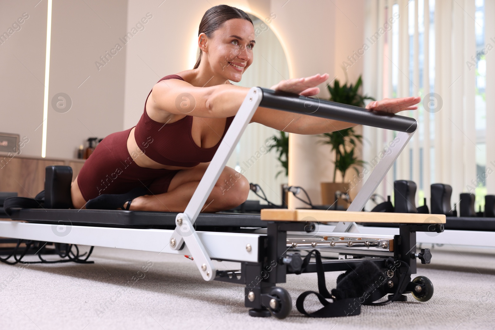 Photo of Woman exercising on reformer in pilates studio