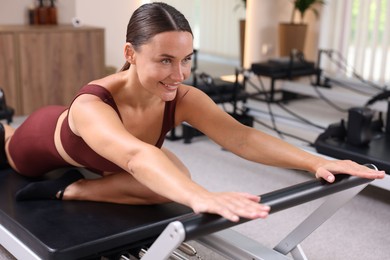 Photo of Woman exercising on reformer in pilates studio