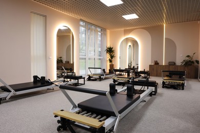 Photo of Many reformer machines in studio. Pilates equipment