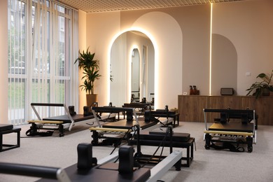 Photo of Many reformer machines in studio. Pilates equipment