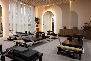 Photo of Many reformer machines in studio. Pilates equipment