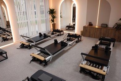 Photo of Reformer machines and mirrors in studio. Pilates equipment