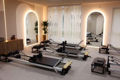 Photo of Many reformer machines in studio. Pilates equipment