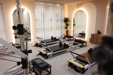 Photo of Many reformer machines in studio. Pilates equipment