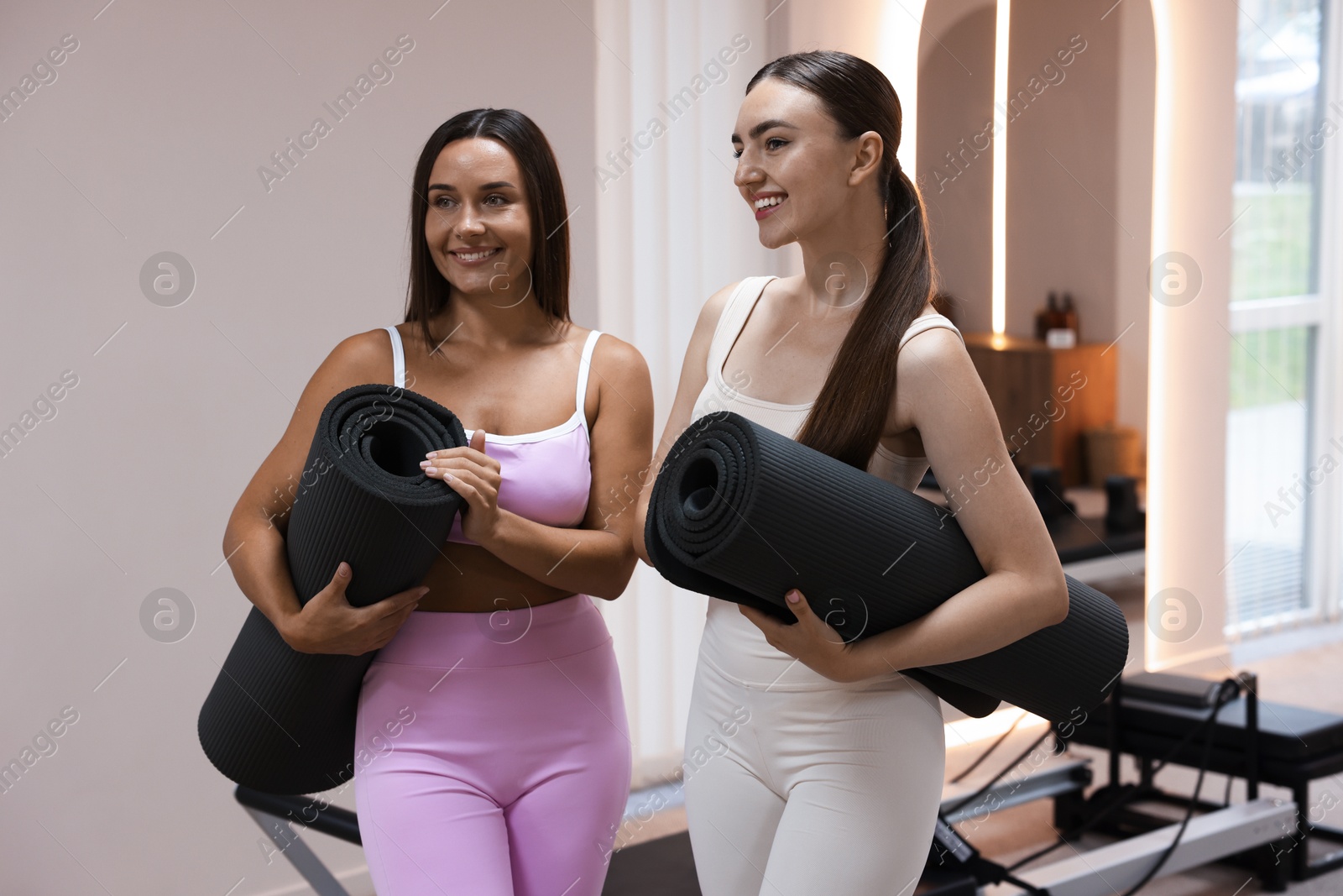 Photo of Women with fitness mats in pilates studio