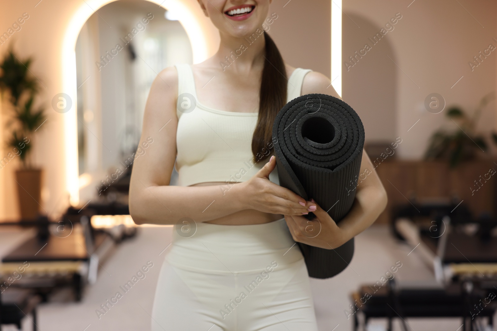 Woman with fitness mat in pilates studio, closeup Photo of Woman with fitness mat in pilates studio, closeup