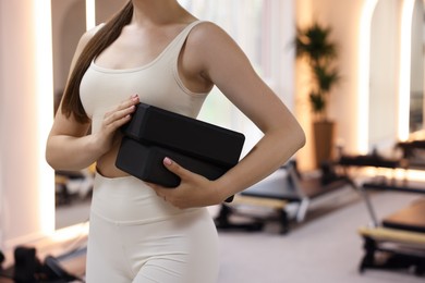 Photo of Woman with foam blocks in pilates studio, closeup. Space for text