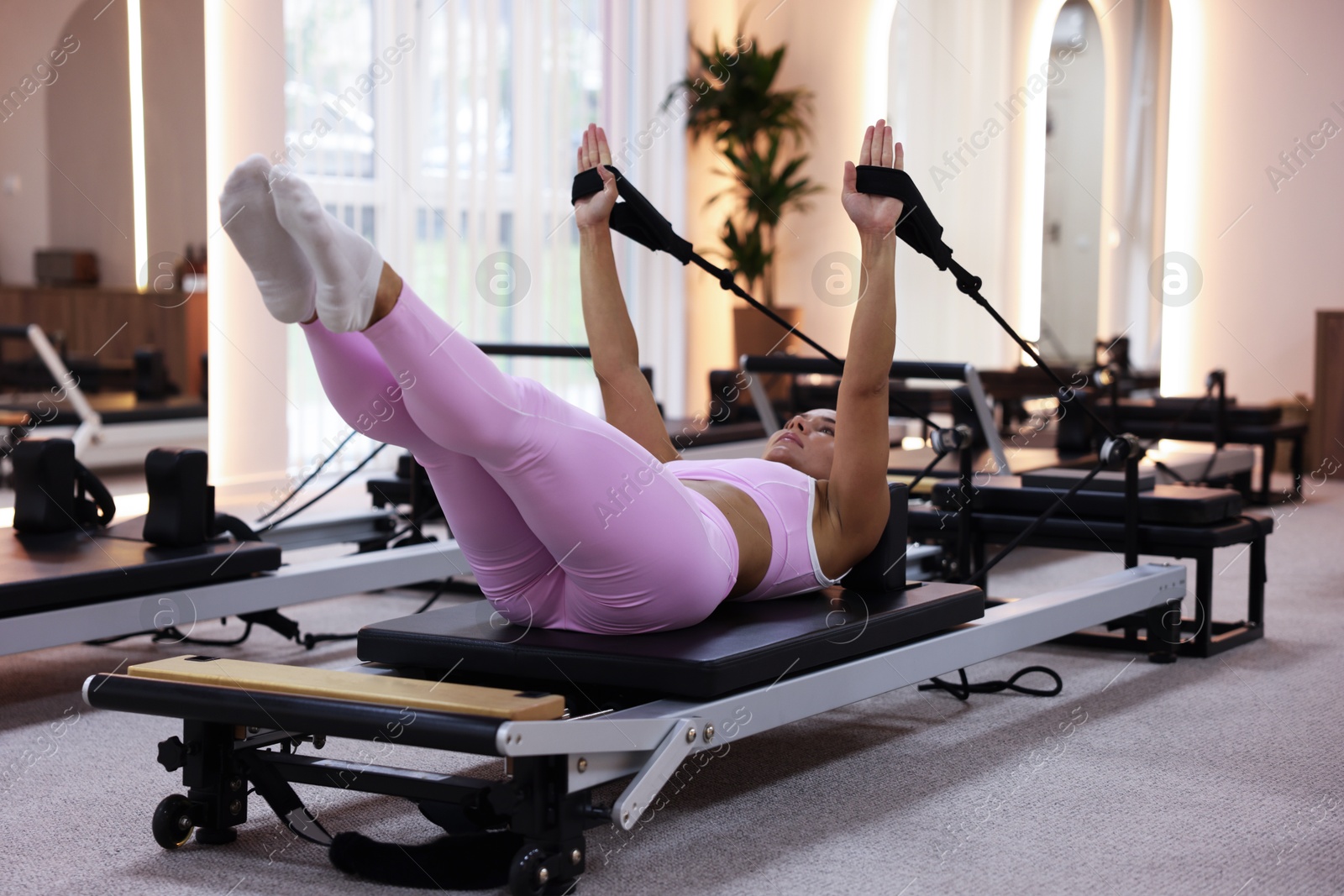 Photo of Woman exercising on reformer in pilates studio