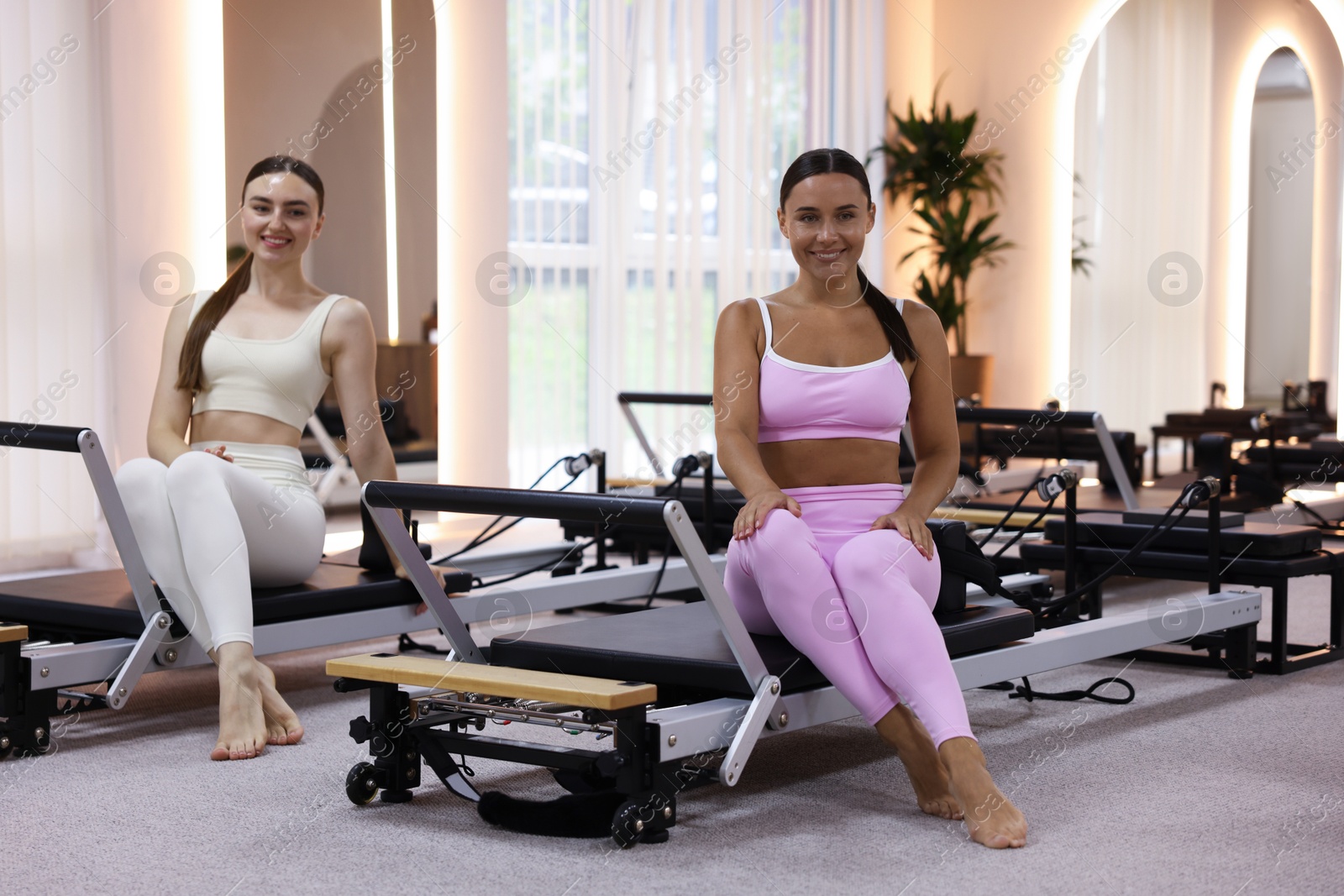 Photo of Woman and pilates instructor on reformers in studio