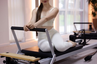 Photo of Woman on reformer in pilates studio, closeup
