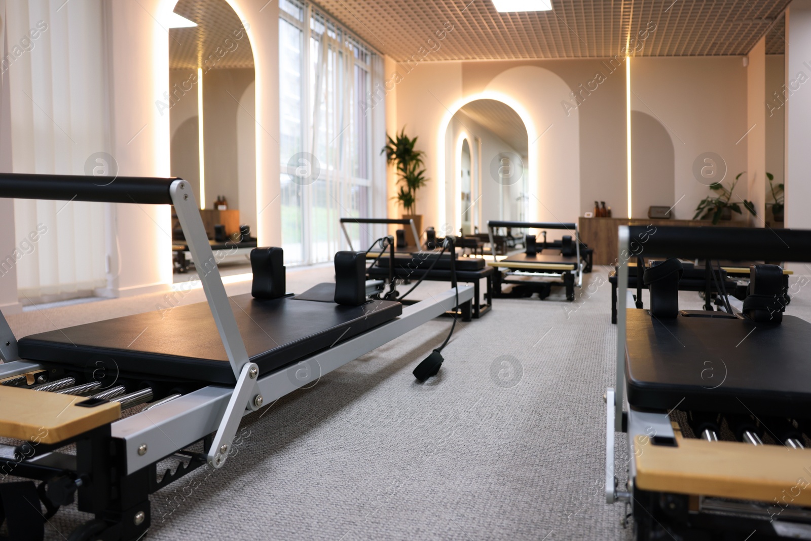 Photo of Many reformers in studio, closeup. Pilates equipment