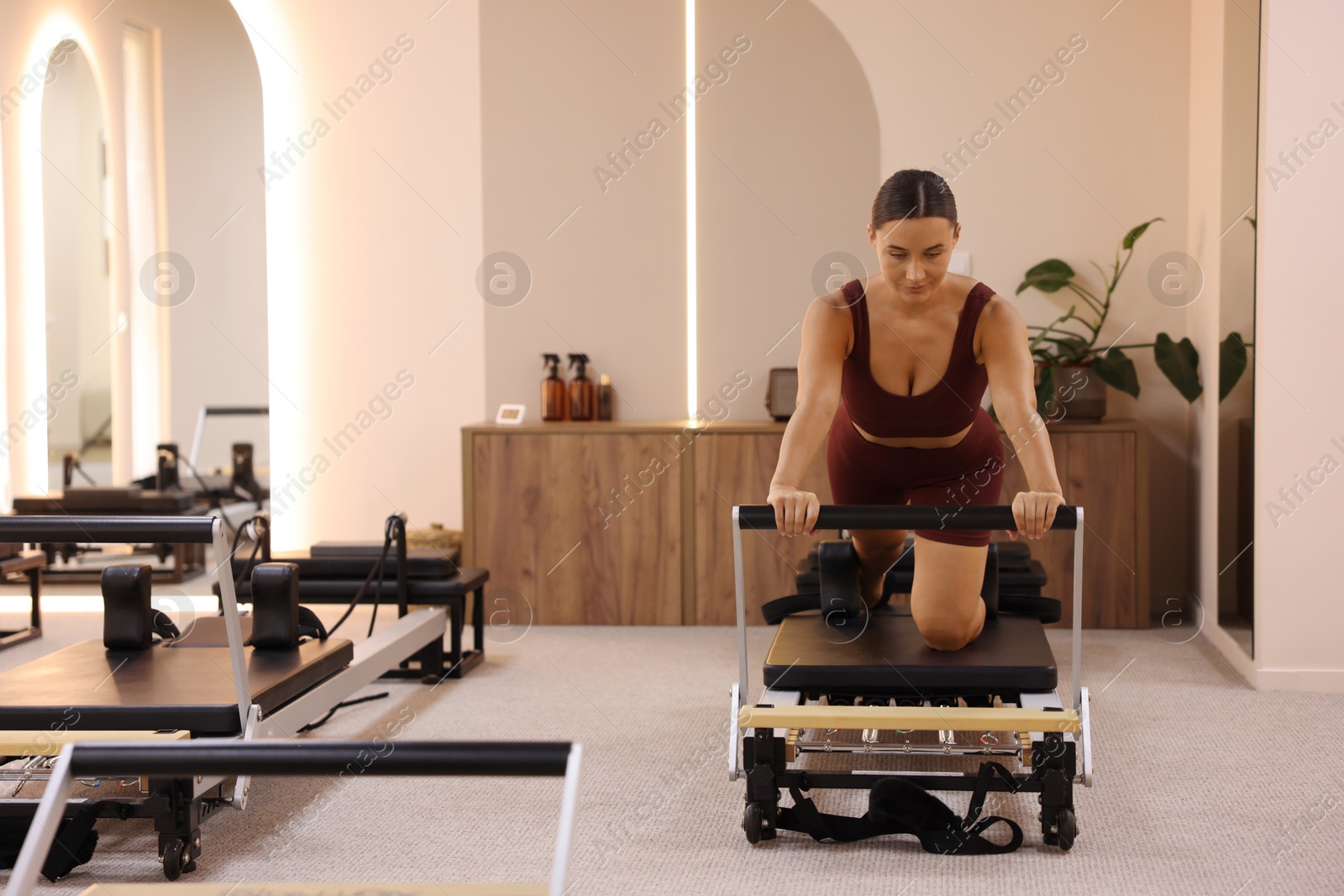 Photo of Woman exercising on reformer in pilates studio