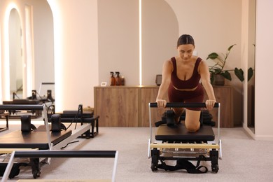 Photo of Woman exercising on reformer in pilates studio