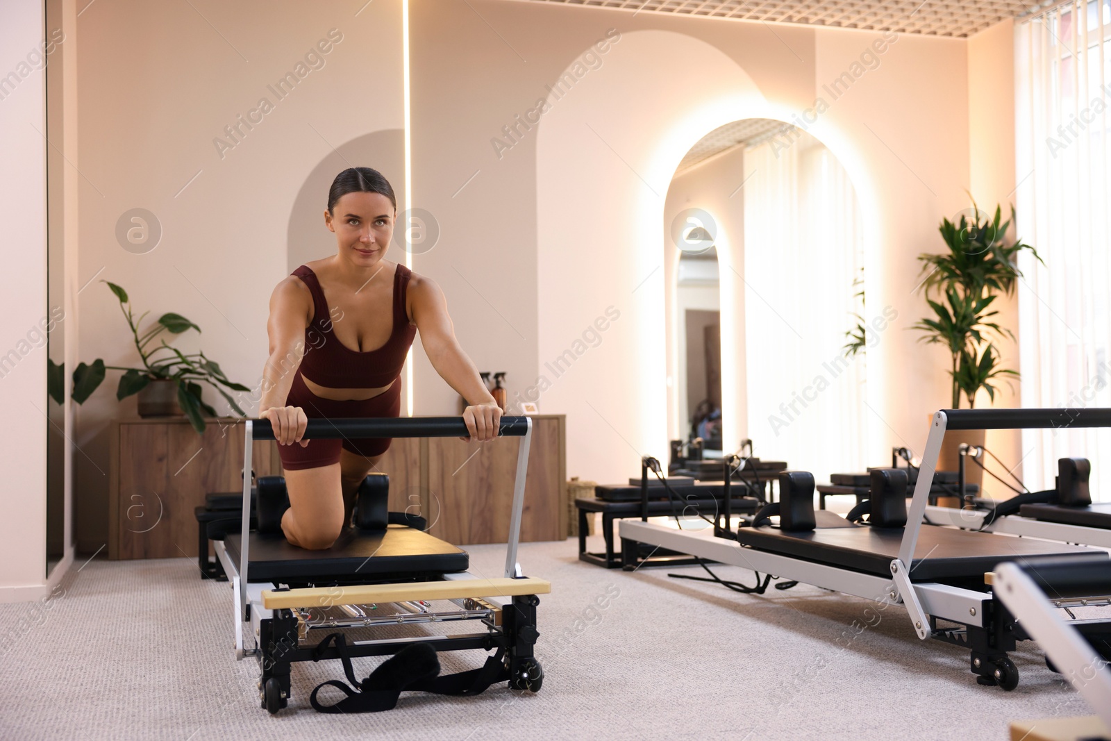 Photo of Woman exercising on reformer in pilates studio