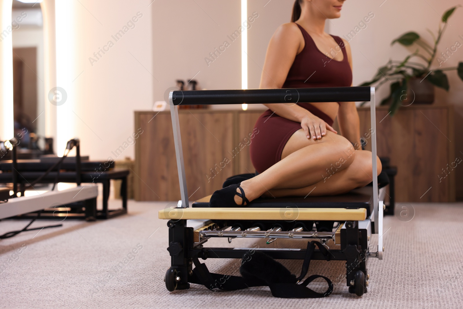 Woman on reformer in pilates studio, closeup Photo of Woman on reformer in pilates studio, closeup