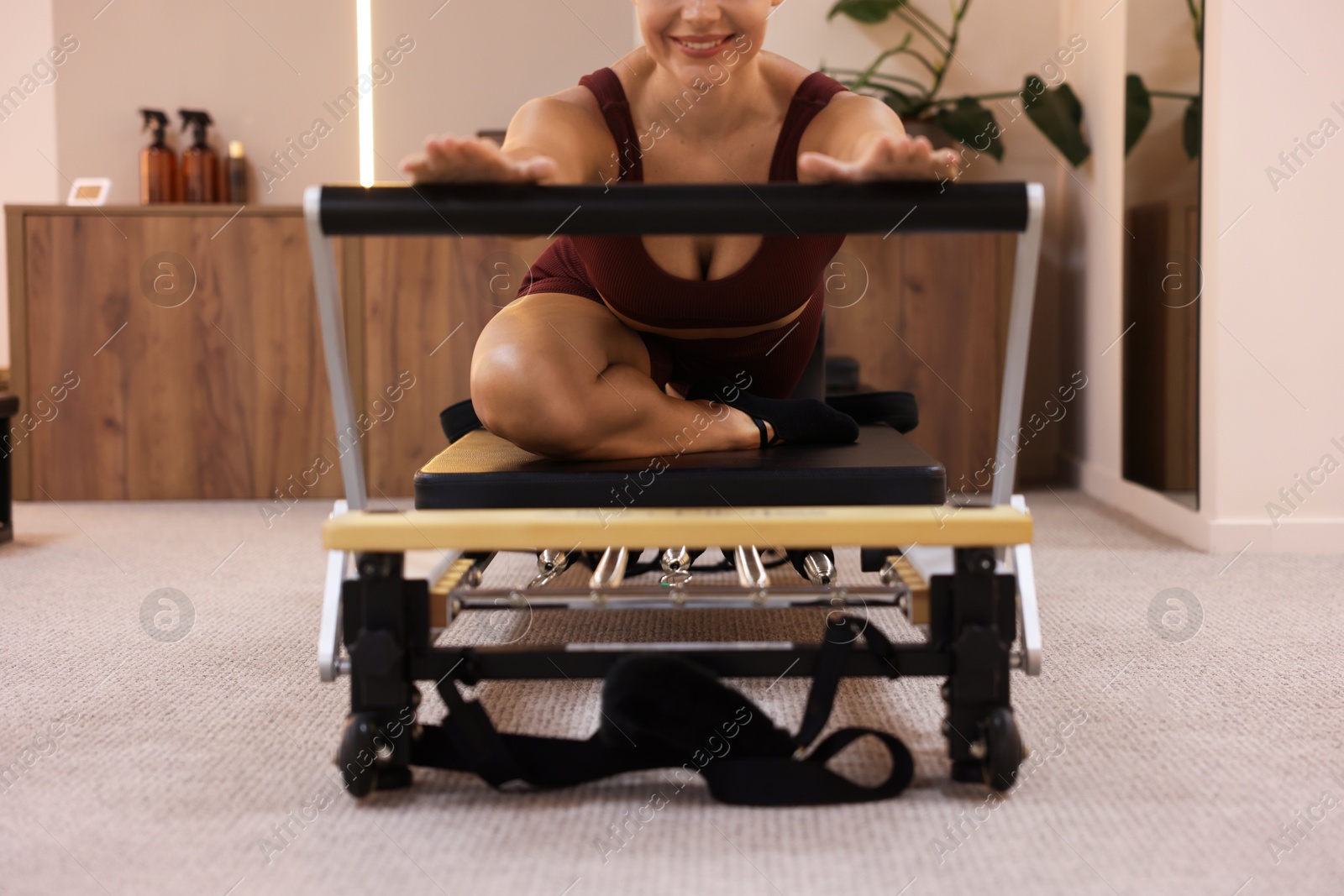 Woman exercising on reformer in pilates studio, closeup Photo of Woman exercising on reformer in pilates studio, closeup