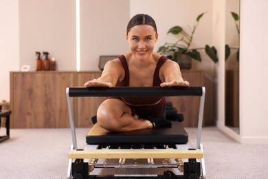 Photo of Woman exercising on reformer in pilates studio